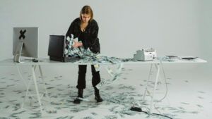 Person handling large stacks of cash spilling out of a briefcase, symbolizing financial management and potential debt restructuring fraud.