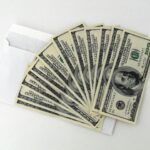 Envelope with stacked hundred-dollar bills, representing financial recovery and cash flow solutions for businesses and individuals seeking effective debt recovery strategies.
