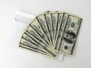 Envelope with stacked hundred-dollar bills, representing financial recovery and cash flow solutions for businesses and individuals seeking effective debt recovery strategies.
