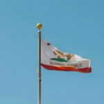 California state flag waving on a flagpole, symbolizing legal regulations such as the statute of limitations on debt in California.
