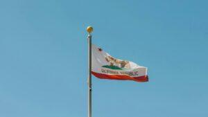 California state flag waving on a flagpole, symbolizing legal regulations such as the statute of limitations on debt in California.
