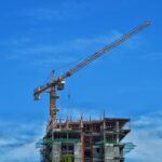 Construction site with a crane and building under development, symbolizing challenges in rising costs, payment delays, and the importance of debt recovery in the industry.