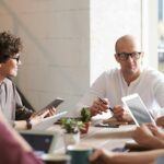 Team discussion in a modern office setting, representing strategic approaches to resolve debt collection challenges for B2B SaaS subscription-based businesses.