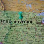 Close-up of U.S. map with green pushpin near Nebraska, symbolizing the geographic filing of abstracts of judgment to secure liens and enforce creditor priority