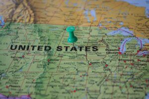 Close-up of U.S. map with green pushpin near Nebraska, symbolizing the geographic filing of abstracts of judgment to secure liens and enforce creditor priority