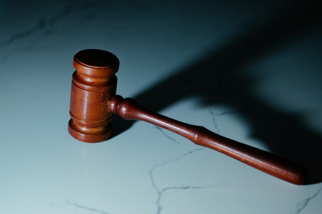 Close-up of a wooden judge’s gavel on a marble surface with dramatic lighting—representing post-judgment discovery procedures in California and the power courts have to compel asset disclosures